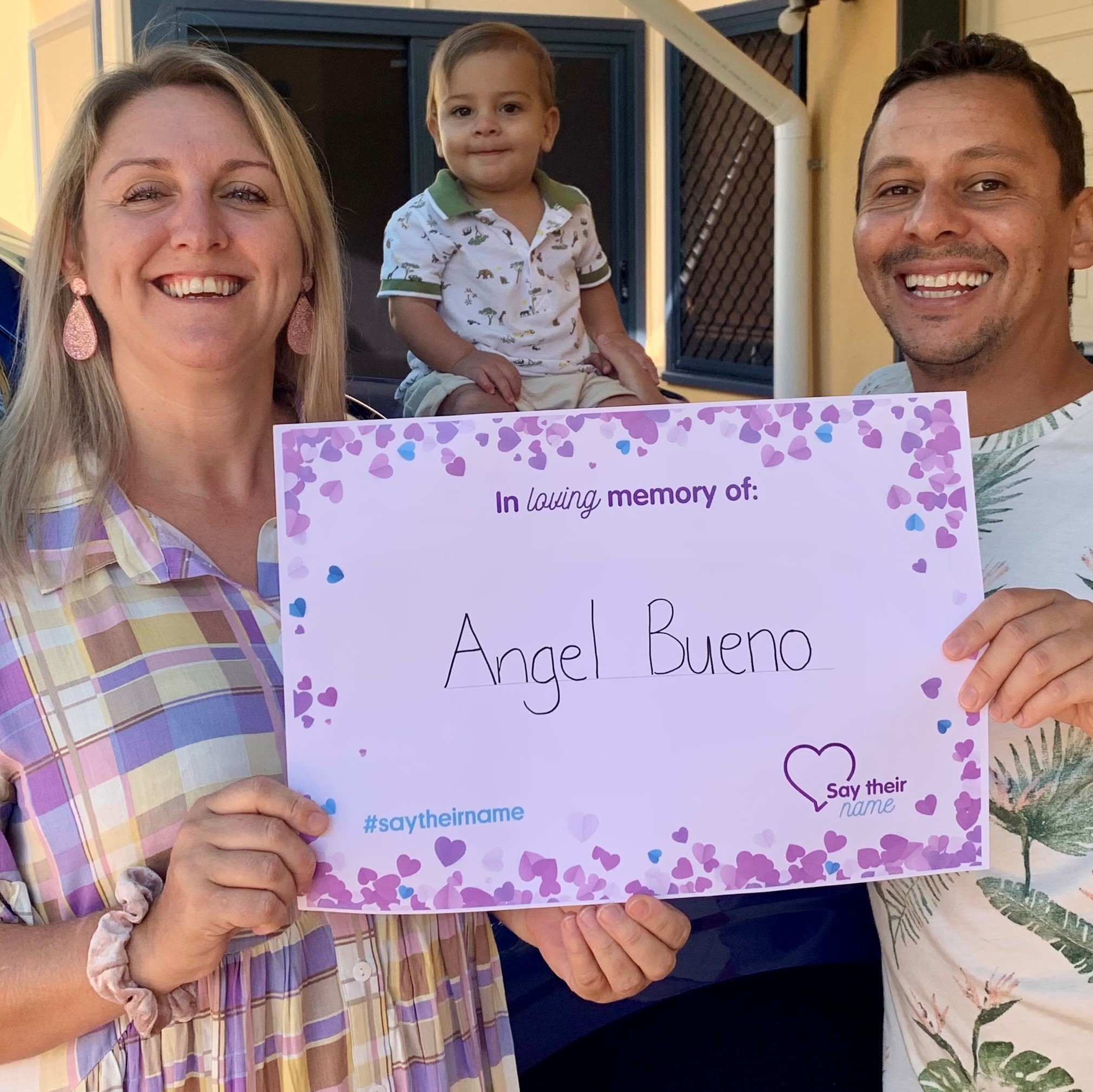 Paula and Ederson (Eduardo in the back ground) holding a sign to remember Angel